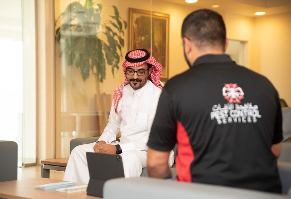 TRAP pest control expert sitting with a customer explaining about disinfection services